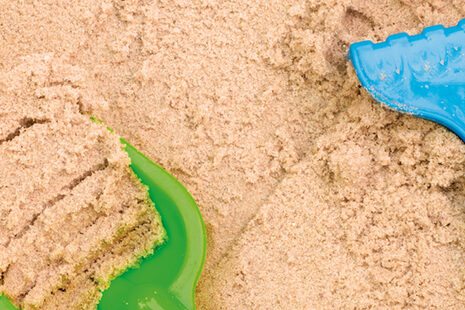 Zwei Schaufeln liegen im Sand